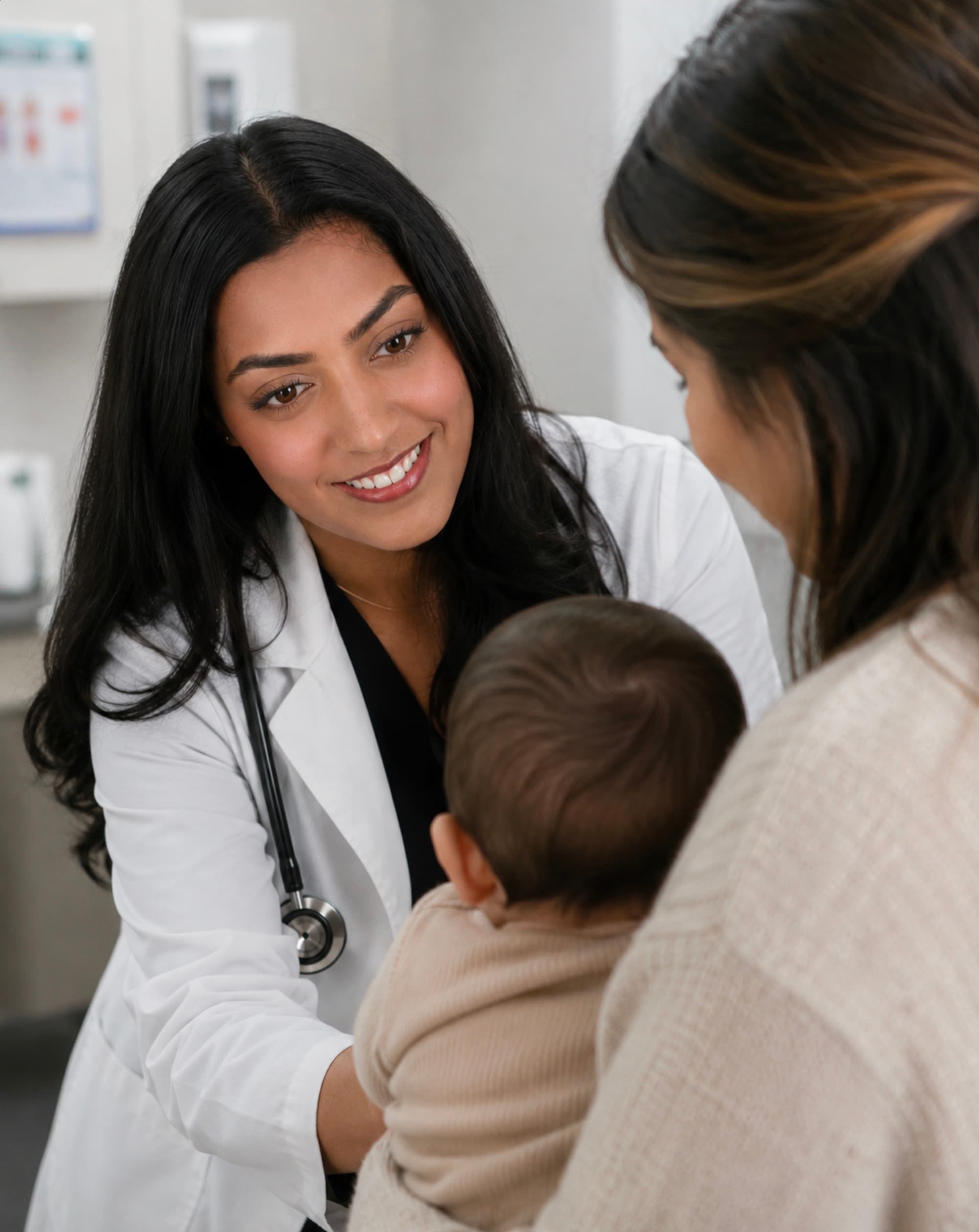 Dr. Sarah Mitchell talking with a mother and her baby during an exam-room visit